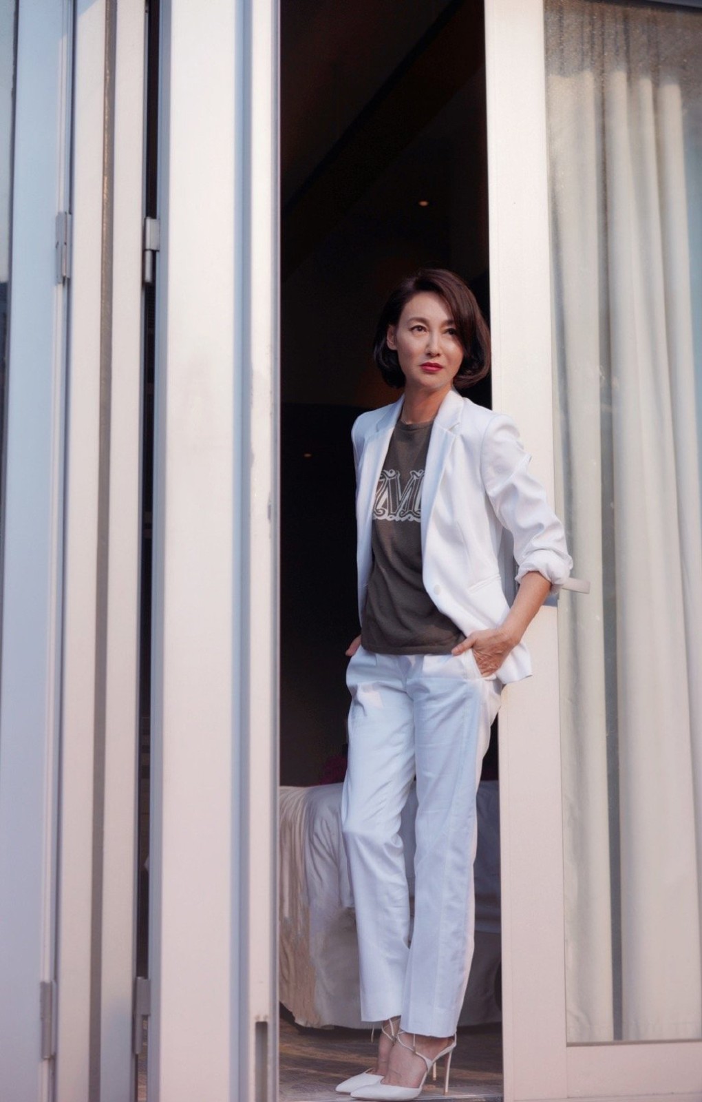 她60岁依旧未婚，穿挂脖层叠雪纺衫配竖纹西装，霸气不失清爽