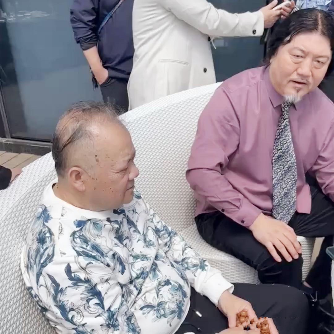 64岁毕福剑现身聚会，翘二郎腿抽烟姿势熟练，与网红合影被挤一旁